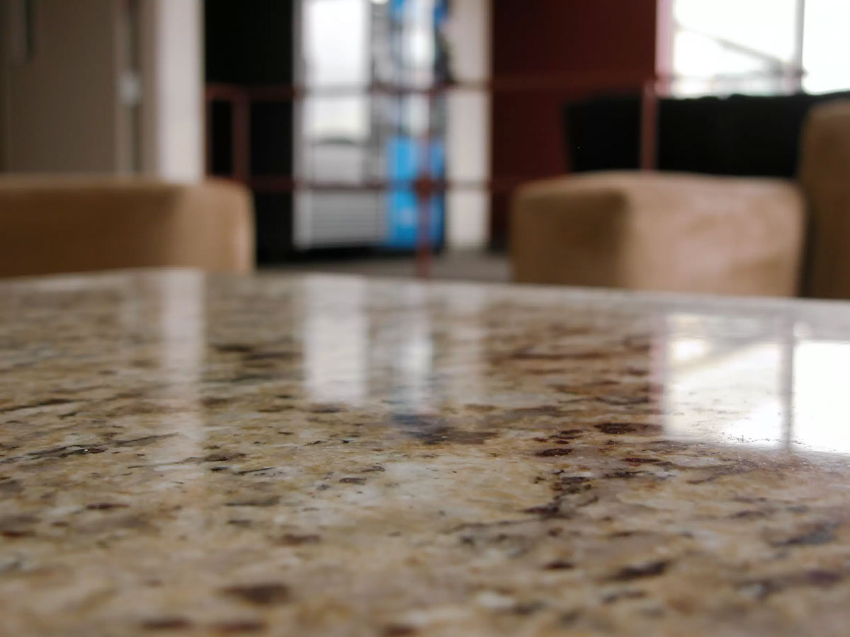 A beautiful naturally marbled stone countertop reflects the sunlight in a modern apartment.